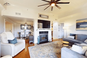 A spacious living room with a fireplace, a ceiling fan, and a large painting on the wall. - Misty Mornings at Sugar Top (Sugar Mountain)