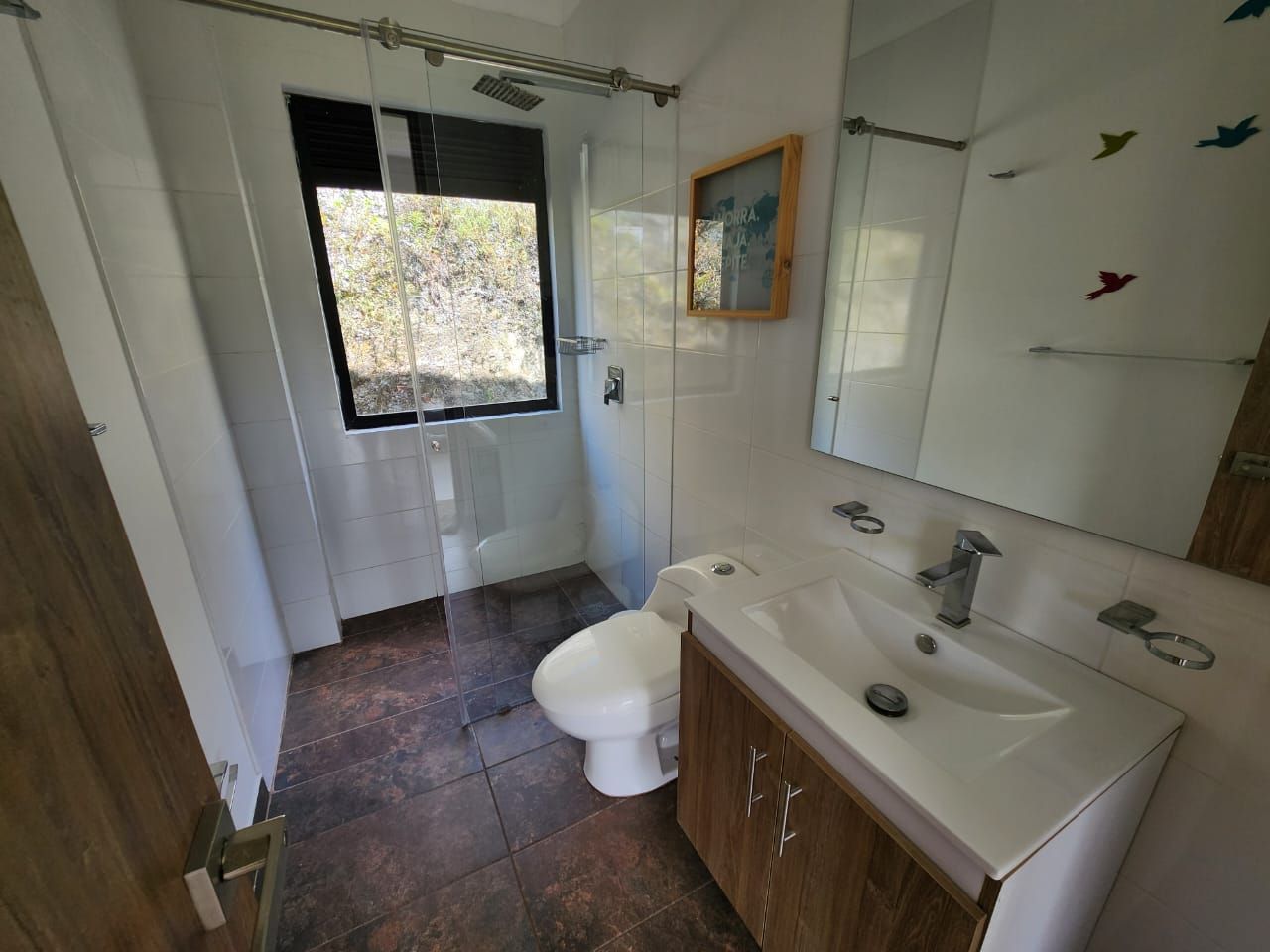 A bathroom with a toilet, sink, and shower.