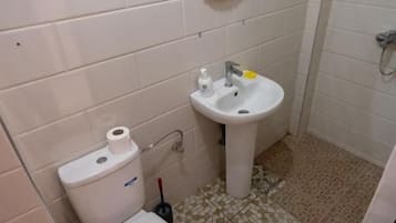 Un baño con inodoro, lavamanos y espejo.