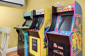 Drei Spielautomaten mit farbenfrohen Designs und der Aufschrift 'PAC-MAN'.