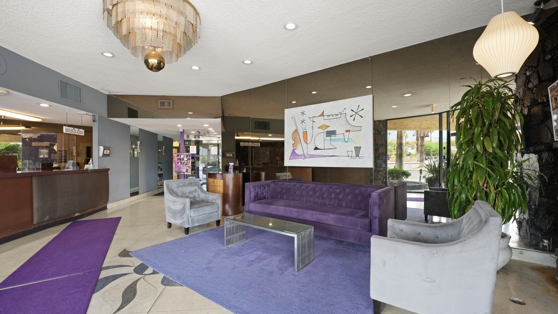 A lobby with a reception desk, seating area, and a large window.