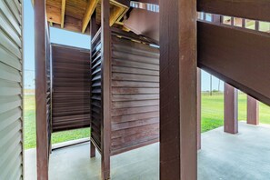 A wooden structure with a partially open door, revealing a grassy area outside. - 2nd Row Getaway with Gulf Views, Coastal Charm & Easy Beach Access (Galveston)