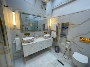 Un baño moderno con dos lavamanos, un espejo grande y un inodoro.