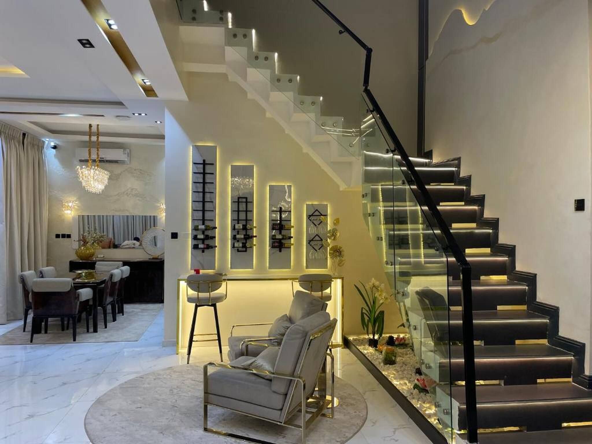 A modern interior with a staircase, a dining area, and a seating area.