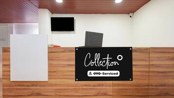 Una reception con un cartello che riporta 'Collection' e 'OYO-Serviced'.