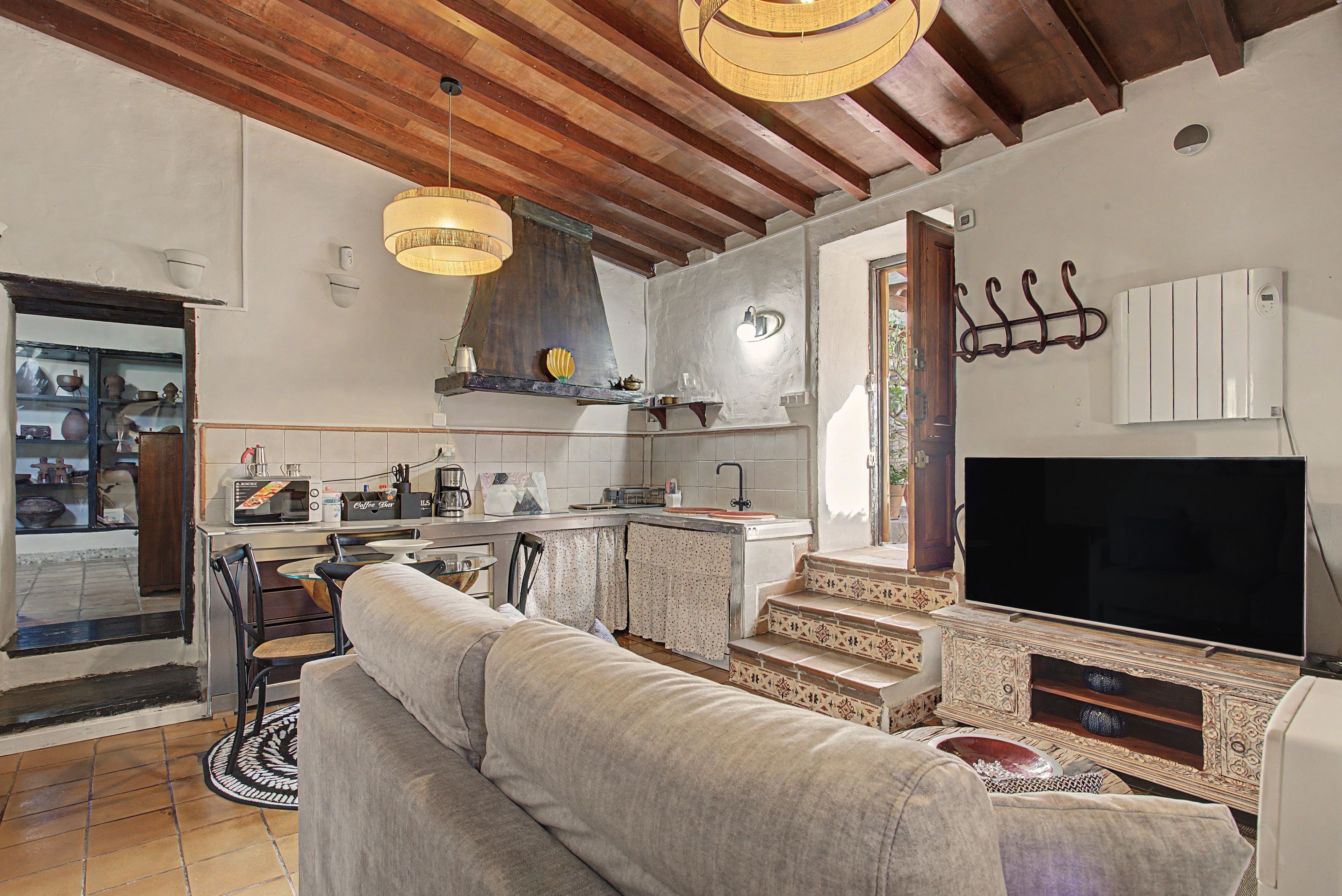 Una cocina moderna con comedor, sofá y televisor.