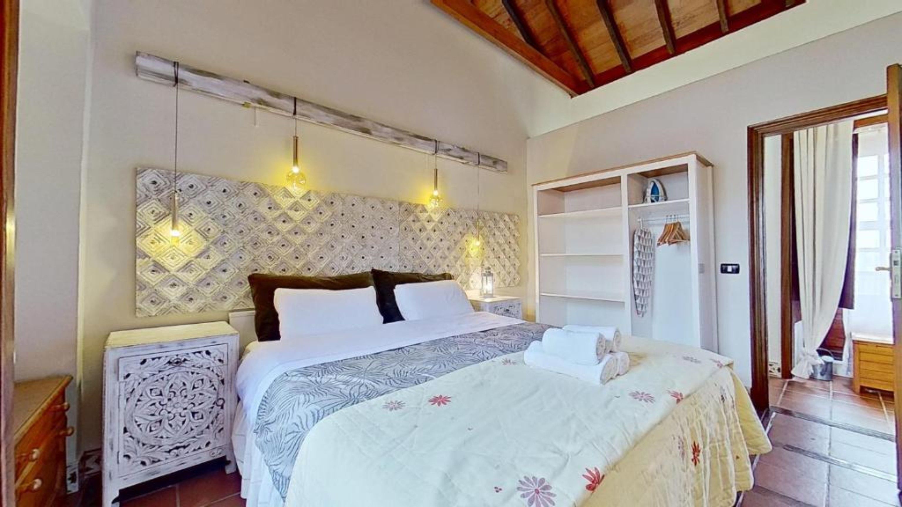 Une chambre à coucher avec un grand lit, une armoire et une table de chevet.