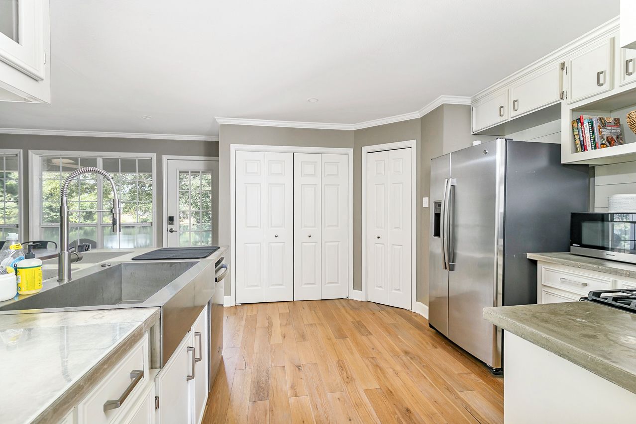 Una cocina moderna con refrigerador de acero inoxidable, puertas dobles y microondas integrado.