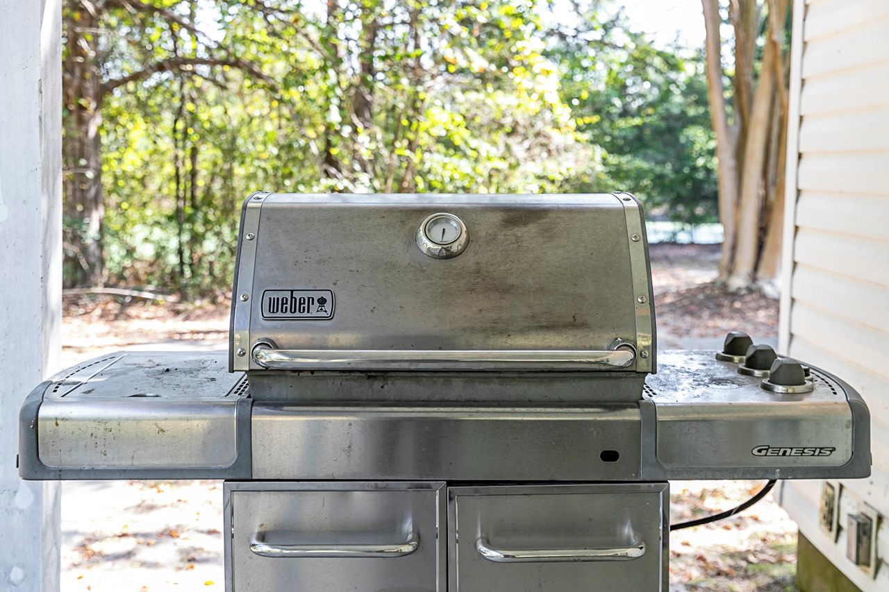 Un barbecue d’extérieur en acier inoxydable, orné du logo « Wedge », doté d’un bouton de contrôle et portant la marque « Genesis ».
