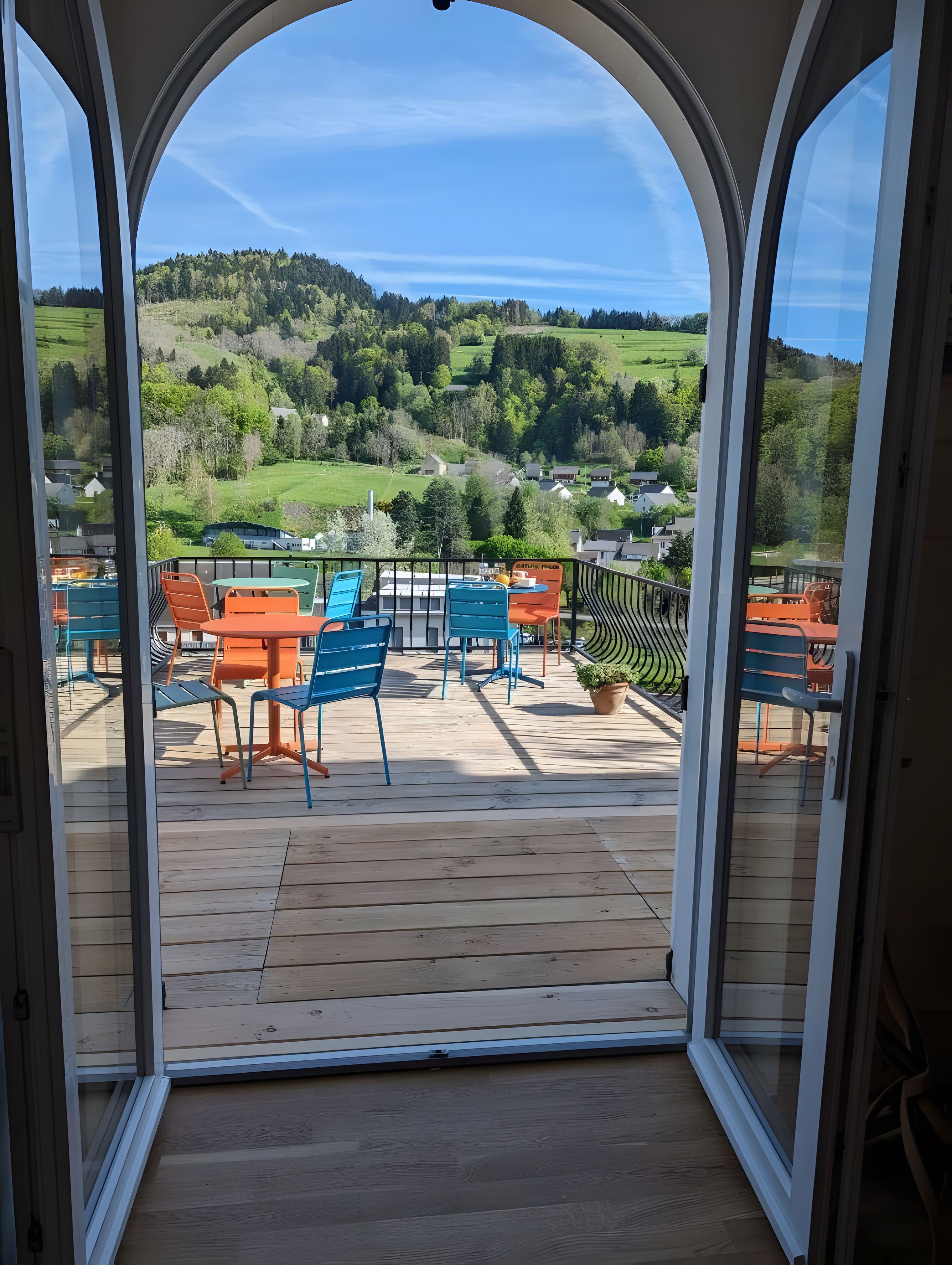 Un balcón con vistas a un paisaje verde y casas.