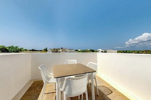 A rooftop terrace with a table and chairs, a clear sky, and distant buildings. - 1BR Condo Near Akumal Beach, Rooftop Pool (Akumal)