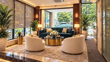 A modern lobby with a sofa set, round coffee table, and potted plants.