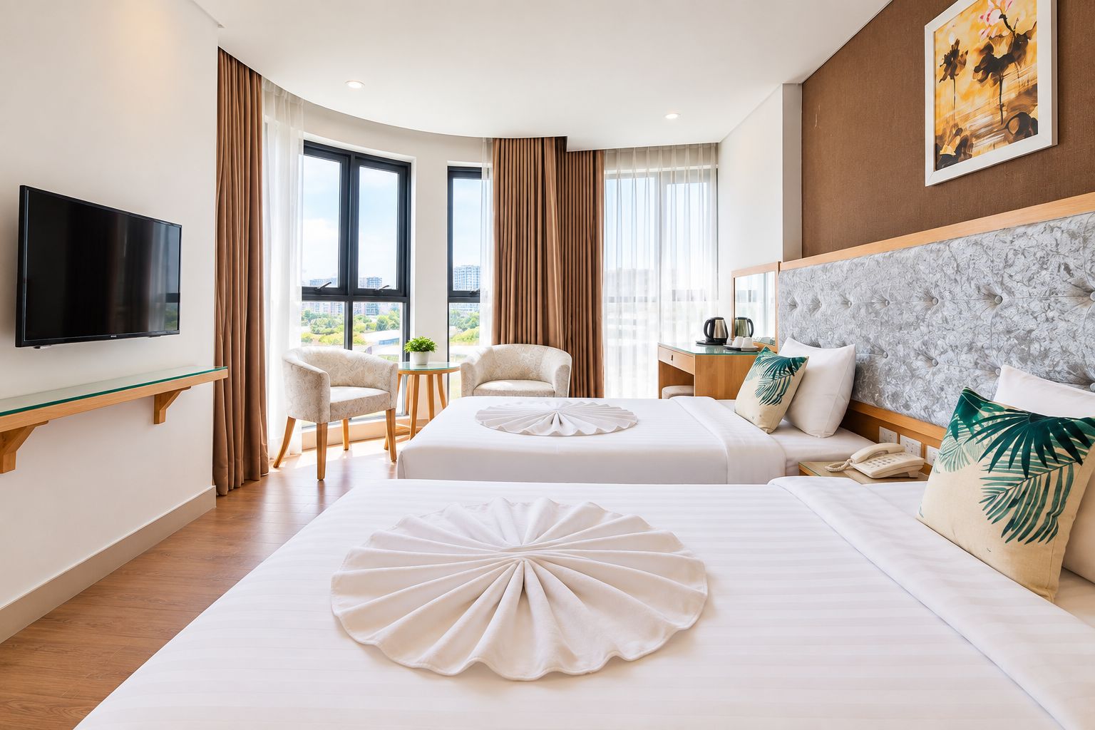 A hotel room with two beds, a flat-screen TV, a desk with a chair, and a view of the city.