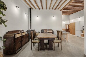Cuina moderna amb una illa central, armaris de fusta i una zona de menjador amb taula i cadires grans.