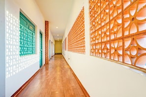Un pasillo con paredes estampadas y suelo de madera.
