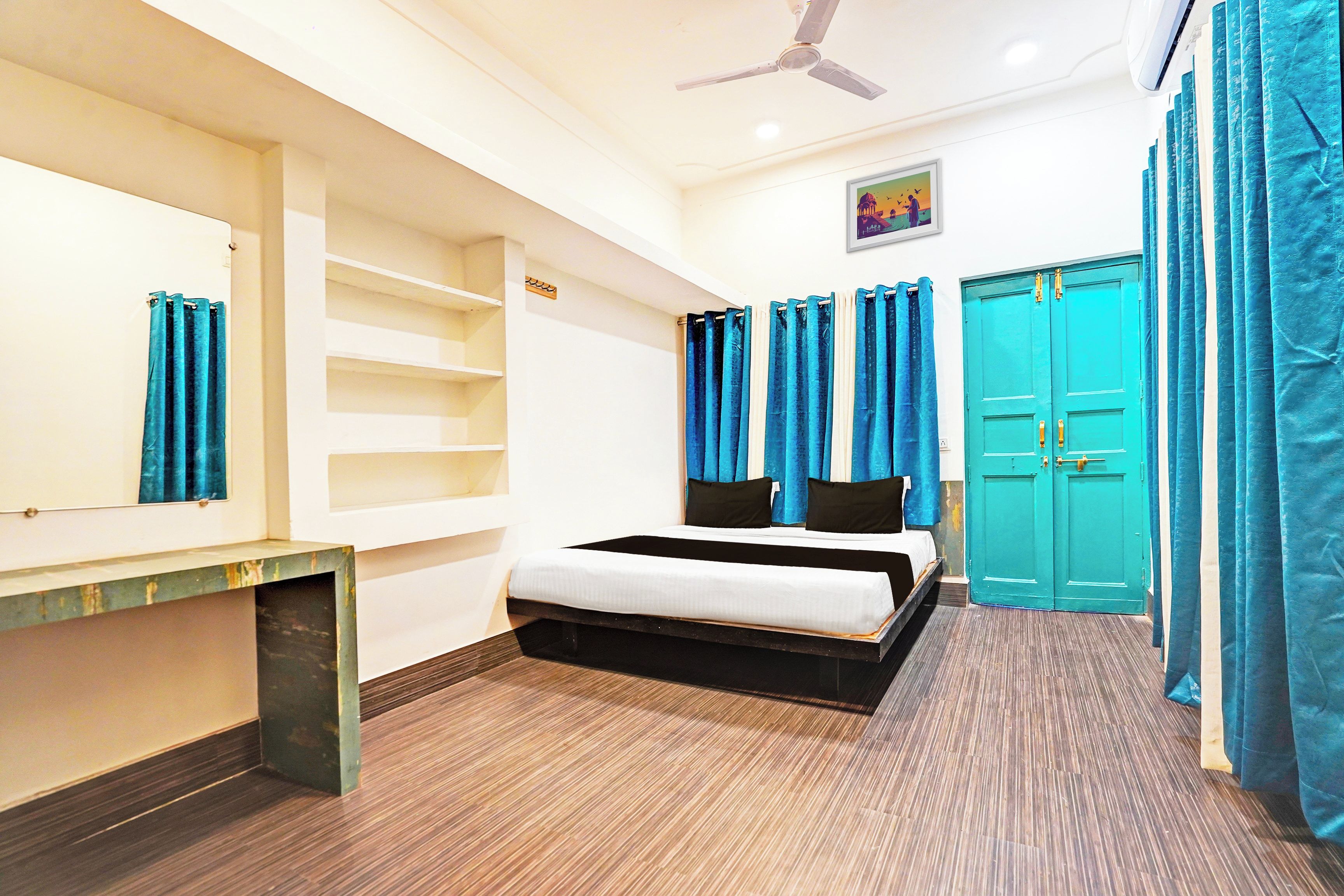 A bedroom with a bed, a desk, a wardrobe, and a ceiling fan.
