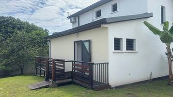 Un bâtiment à deux étages, doté d’un toit plat, d’une porte d’entrée et d’un petit porche avec une balustrade en bois.