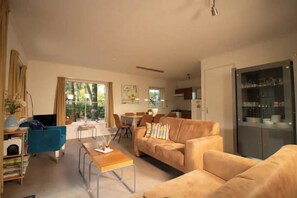 A modern living room with a sofa, coffee table, and dining area. - Zwaontje 1–90 (Winterswijk)