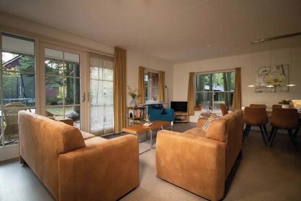 A spacious living room with a sofa set, a coffee table, and a television.