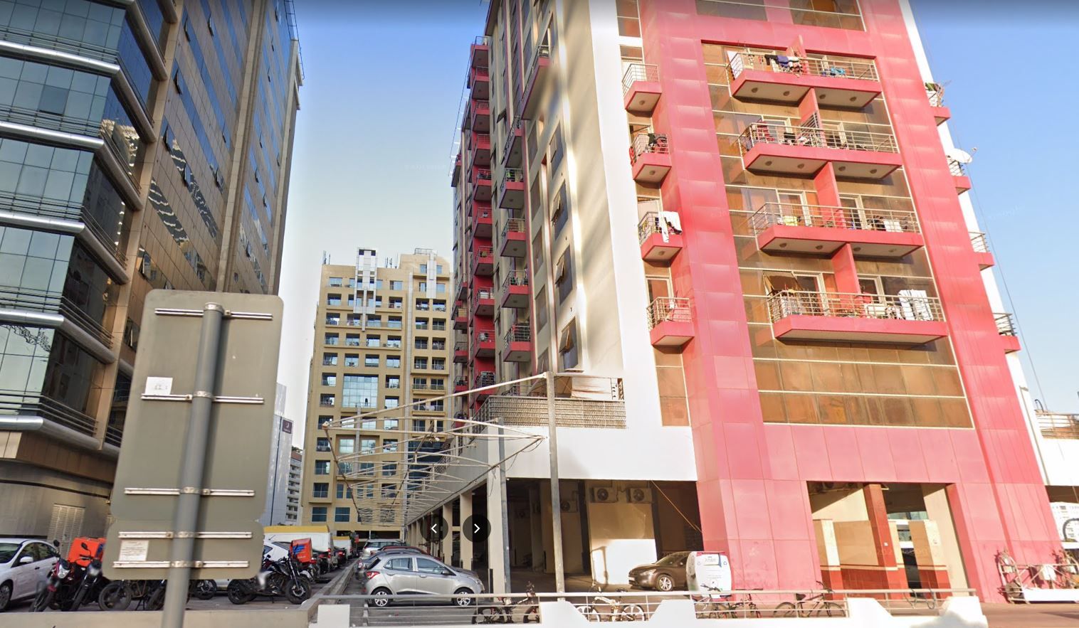 Un edificio de varios pisos con balcones y una entrada cubierta.