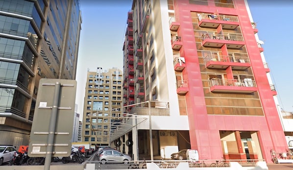 A multi-story building with balconies and a covered entrance. - Cityscape Partition Room in Tecom (Dubai)