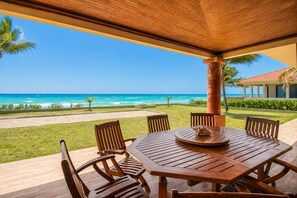 A wooden table and chairs under a wooden canopy with a view of the ocean. - Beachfront 5BR Villa Playacar, Private Pool (Playa del Carmen)