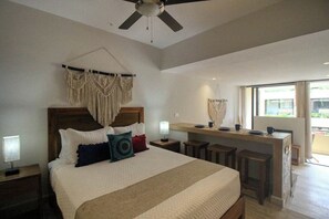 A bedroom with a bed, a desk, and a ceiling fan. - Centro Playa Studio - Rooftop Pool & Gym (Playa del Carmen)