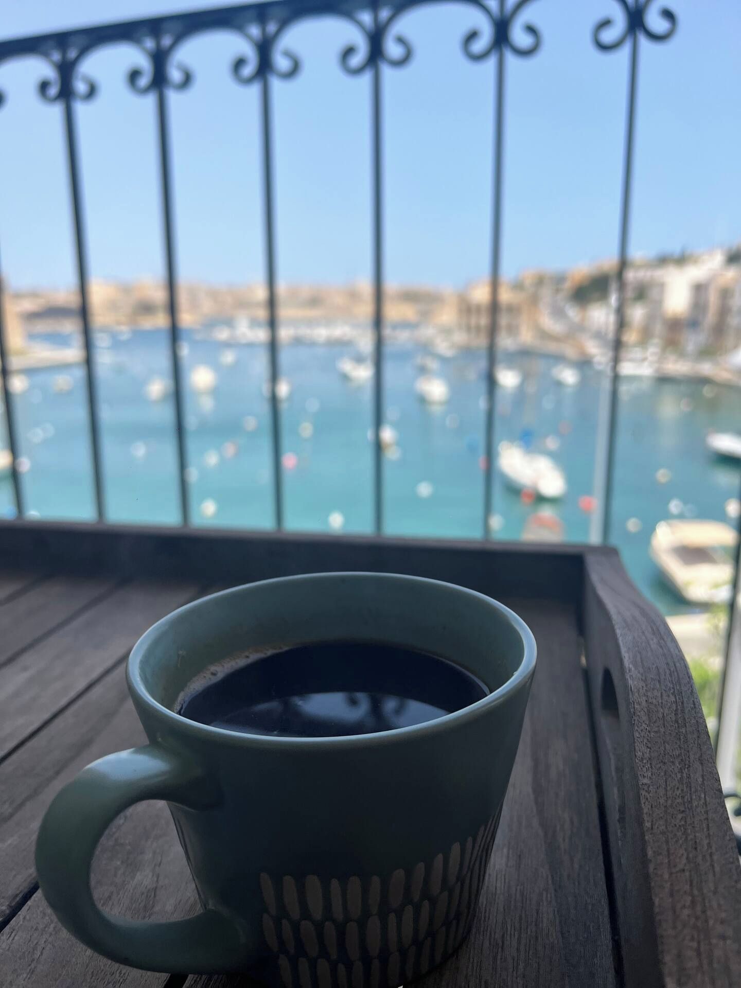 A green mug with a handle on a wooden surface.