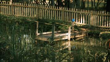 A wooden bridge over a body of water with a fence in the background.