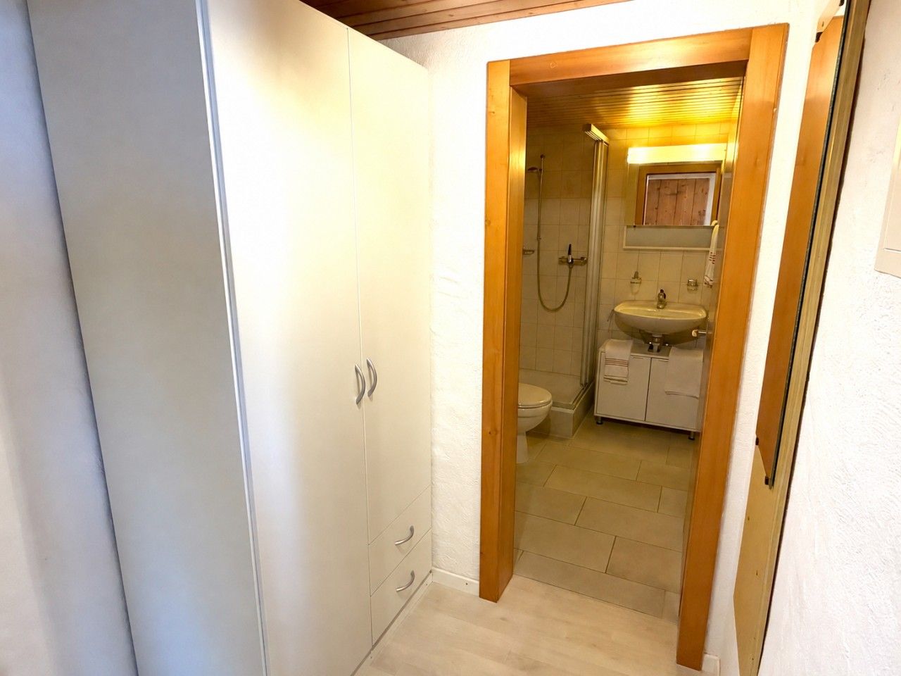 Une petite salle de bain comprenant une douche, des toilettes et un lavabo.