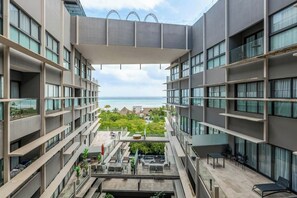 A modern hotel with multiple balconies overlooking a beach. - Ocean-view Condo - Rooftop Infinity Pool & Wifi (Playa del Carmen)