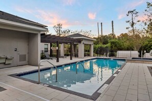 Piscina com área de estar coberta, porta e deck revestido em azulejo.