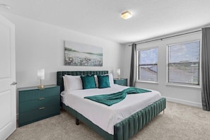A bedroom with a bed, nightstands, a painting, and windows with blinds. - Terra Esmeralda Home Near Disney for 9 Guests (Kissimmee)