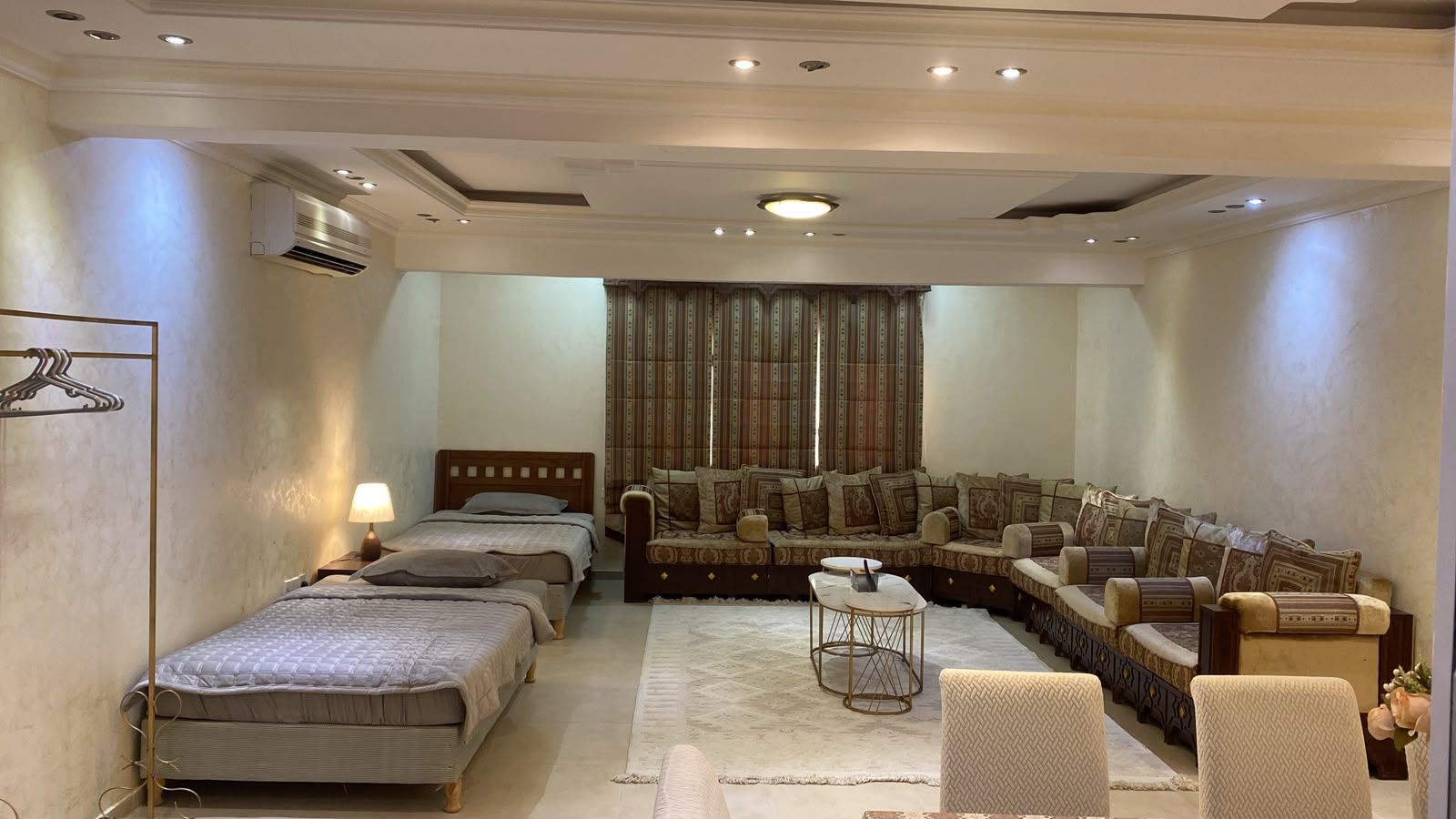 Une chambre d’hôtel avec deux lits simples, un canapé, une petite table et une chaise.