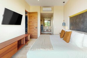 A modern bedroom with a bed, a TV, and a wooden bench. - Playa del Carmen Condo Rooftop Pool & Balcony (Playa del Carmen)
