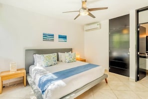 A bedroom with a bed, a ceiling fan, an air conditioning unit, and a door. - Playa Penthouse Rooftop Terrace & Shared Pool (Playa del Carmen)