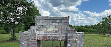 A brick structure with a metal fence and a bench.