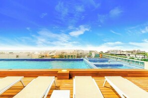 A rooftop pool with lounge chairs and a city view. - Studio With Rooftop Pool Playa del Carmen (Playa del Carmen)