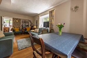 Un salon confortable avec une table à manger, des canapés et un téléviseur.