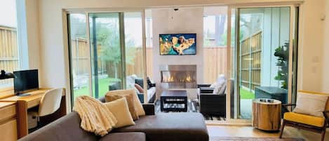 A modern living room with a sofa, coffee table, and a fireplace.