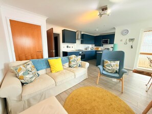A living room with a sofa, armchair, and a round rug. - 3 Seascapes
A bright and modern apartment with lovely views towards Swanage Bay. (Swanage)