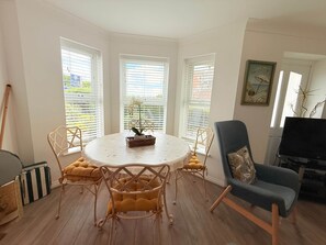 A dining area with a round table, chairs, and a potted plant. - 3 Seascapes
A bright and modern apartment with lovely views towards Swanage Bay. (Swanage)
