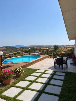 Ein Poolbereich mit Blick auf sanfte Hügel und Windkraftanlagen.