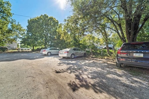 A parking area with multiple cars, trees, and a building in the background. - 3BR 1BA, Sleeps 5 Walk to ISU (Ames)