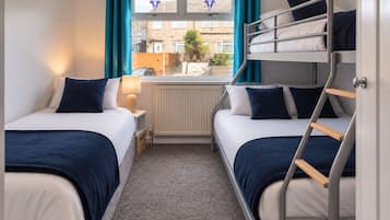 Bright family bedroom with bunk beds, twin bed, and stylish blue accents