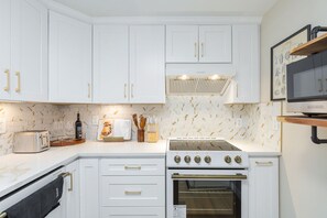 A kitchen with white cabinets, a stove, and a microwave. - Gorgeous 3-bedroom townhome with AC in lovely center of Bellevue (Bellevue)