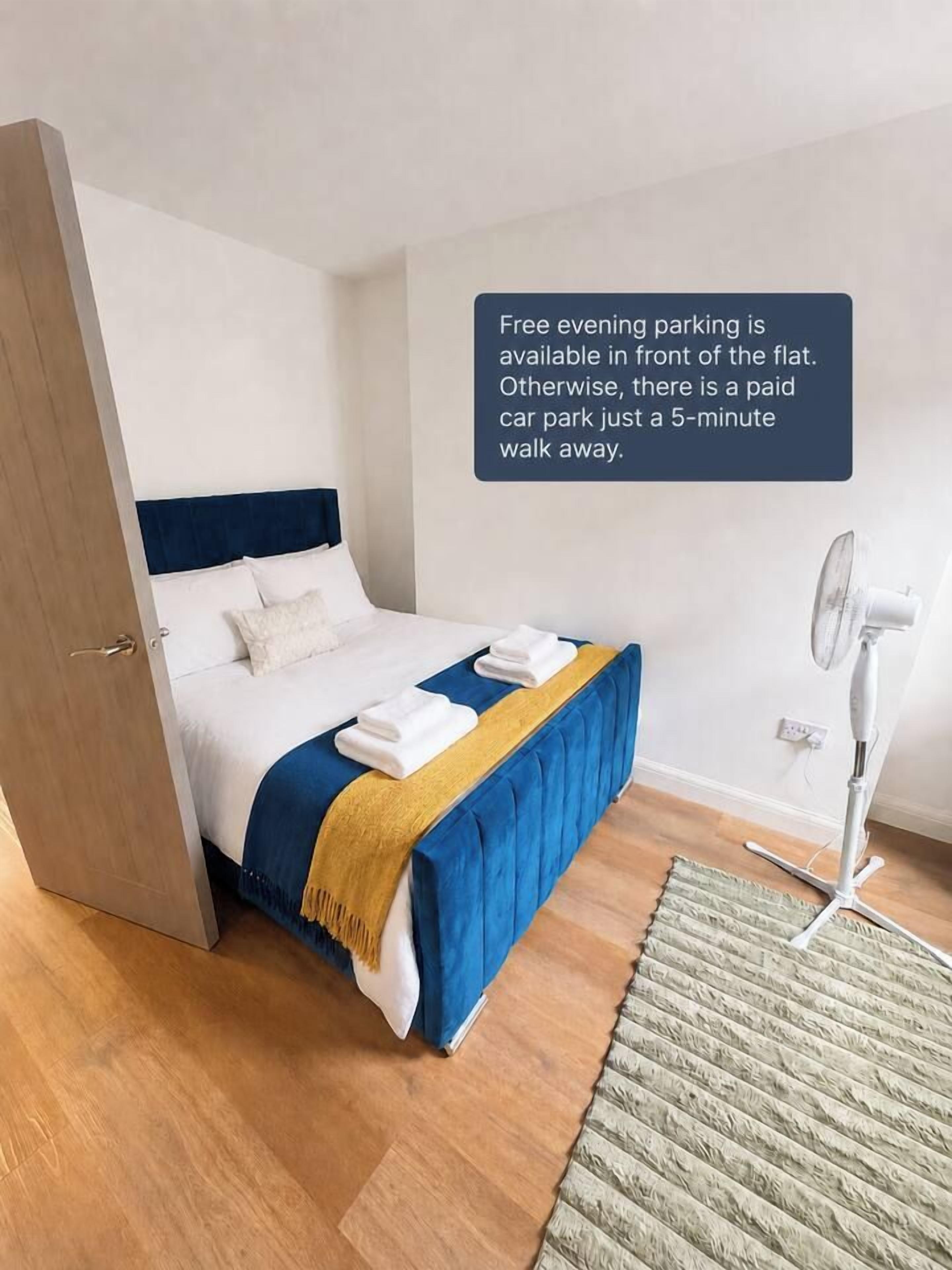 Une chambre d’hôtel avec un lit, un ventilateur de chevet et un avis indiquant si des places de stationnement sont disponibles.