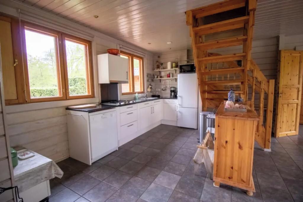 A kitchen with white cabinets, a wooden counter, and a microwave.