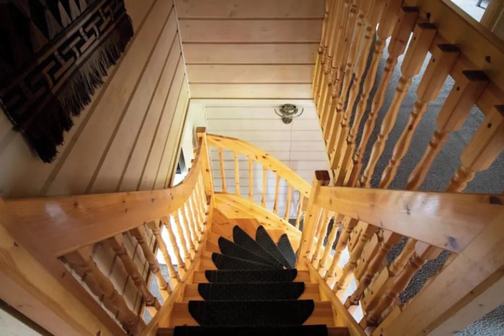 Eine Holztreppe mit Geländer, die zu einer Aussichtsplattform führt.