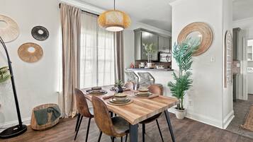 Een eetruimte met een houten tafel, stoelen en een hanglamp.